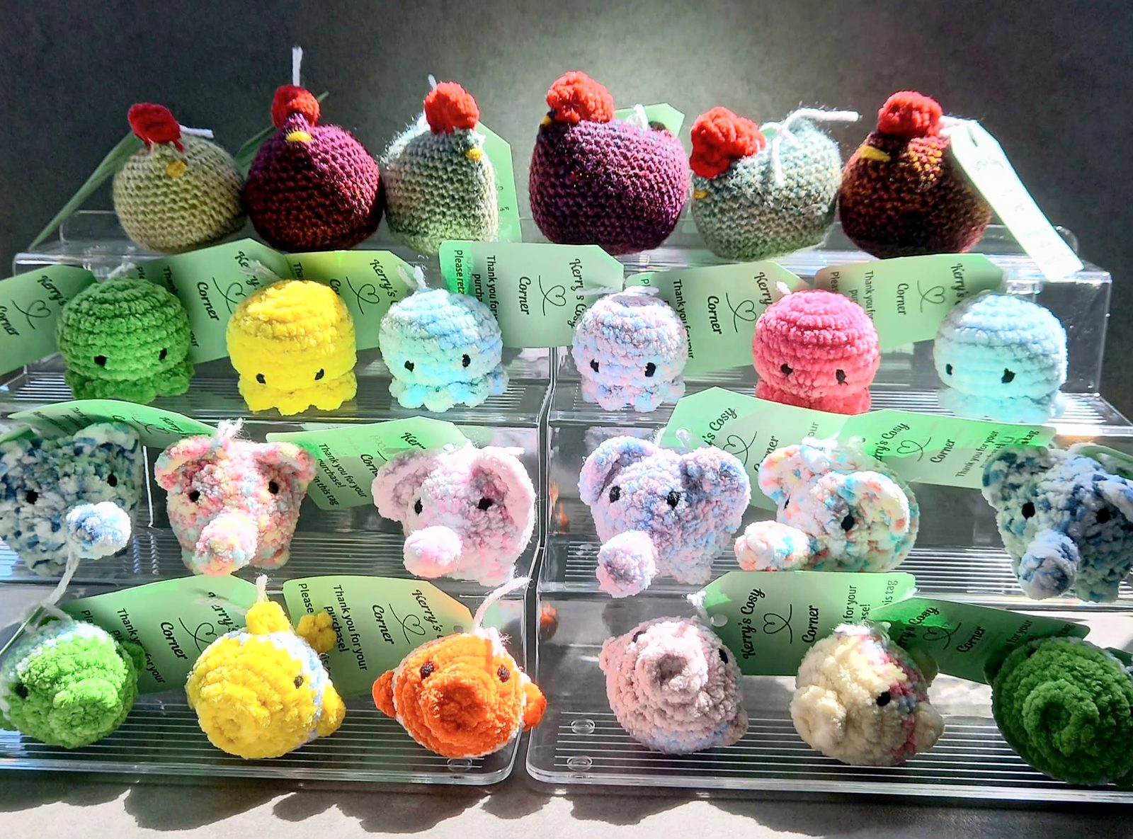 Shelves of Kerry's crocheted chickens, octopuses, elephants and fish, each with a Kerry's Cosy Corner tag