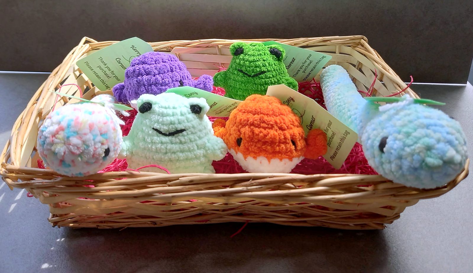 A basket of crocheted frogs, a whale, an octopus and a goldfish