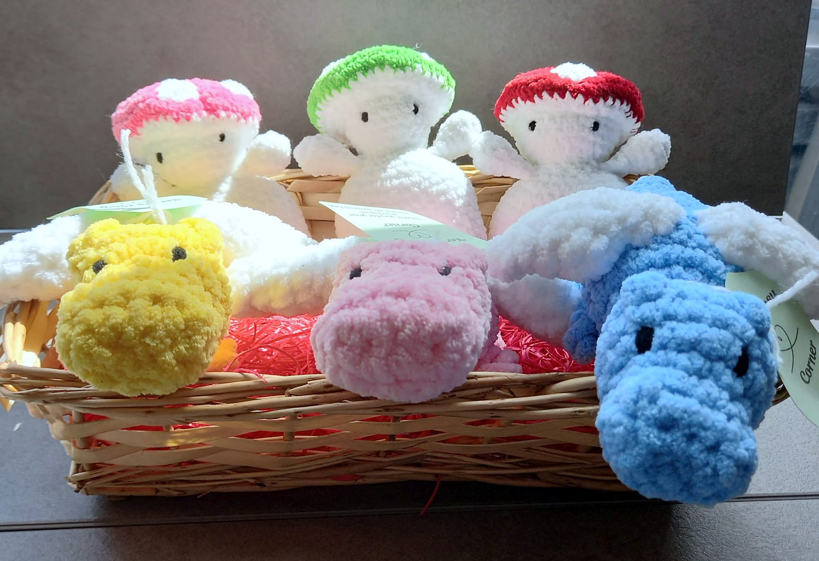 Crocheted mushroom friends with platypuses in a basket