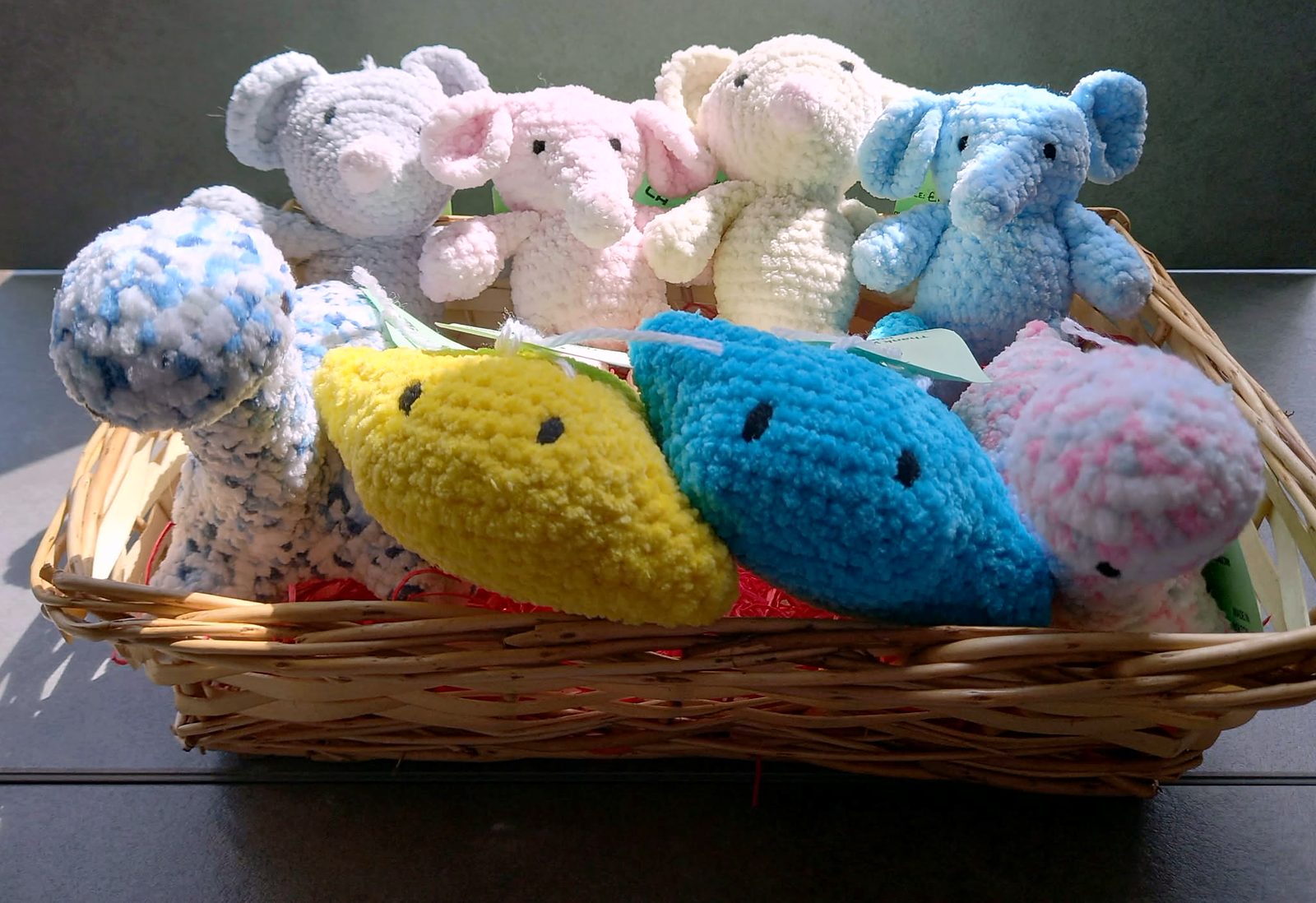 A basket of crocheted elephants, mice, dinosaurs and stingrays